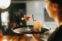 Female server holding a tray of cocktails